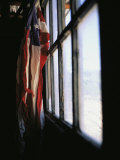 An American Flag Hangs in a Window Photographic Print by Raul Touzon