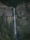 A Tall and Narrow Waterfall Emptying into a Forest of Pines Photographic Print by Sam Abell