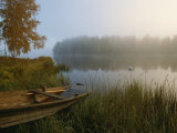 A Weathered Rowboat on the Shore of a Misty Lake Photographic Print by Mattias Klum