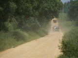 Two Pickups Go Down a Dirt Country Road Photographic Print by Medford Taylor