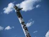 Indian Totem Pole against Blue Sky with Puffy White Clouds Photographic Print by Todd Gipstein