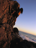 A female climber scales a rock near the Pacific Ocean Lámina fotográfica A female climber scales a rock near the Pacific Ocean Lámina fotográfica