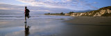 A Man Jogs Along Sands Beach Below Ellwood Bluffs, at Sunset Photographie par Rich Reid