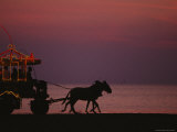 A Horse-Drawn Carriage Rolls Along Jeddahs Waterfront at Sunset Photographic Print