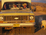 A Dog Stands Outside a Truck with Three Cowboys Photographic Print by Joel Sartore