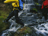 Hikers Cross a Stream by Stepping on Rocks Photographie