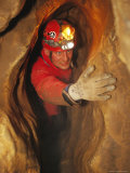 Man in Caving Gear in the Entrance to the Laundry Chute, a Narrow Corridor in the Rats Nest Cave Photographic Print by Mark Cosslett