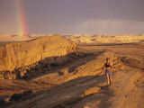 Woman Trail Running in a Rocky Landscape with a Rainbow Photographie