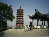Man Cycles Past a Pagoda in Zhouzhong, China Photographic Print
