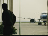 Man at a Chinese Airport Walks Past an Airplane Parked outside Fotografie-Druck von Justin Guariglia