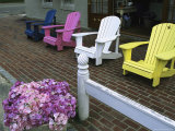Adirondack-Style Chairs on a Brick Sidewalk Outside a Shop Photographic Print