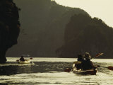 Tourists Kayak Alongside Karst Limestone Formations of Halong Bay Photographic Print by Justin Guariglia