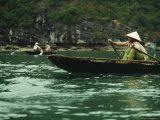 A Woman in a Traditional Boat Rows from Floating Village to Village, Halong Bay Photographic Print by Justin Guariglia