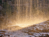 Backlit Drops of Water Pelting Rocks Photographie