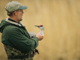 A Man Holds an Injured Sandhill Crane Photographic Print