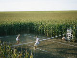An Umpire Watches a Game on a Tennis Court Carved from a Cornfield Impressão fotográfica por Joel Sartore An Umpire Watches a Game on a Tennis Court Carved from a Cornfield Impressão fotográfica por Joel Sartore