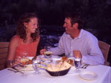 A Young Couple Eats Dinner by a Riverside, Steamboat Springs, Colorado Photographic Print by Taylor S. Kennedy