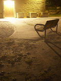 Empty Bench Outside Lighted Building at Night Photographic Print