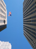 View of American Flag Between Skyscrapers Lámina fotográfica