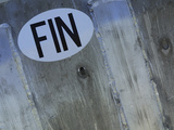 Close-up of a Gray Surface with a White Sticker and Black Lettering Photographic Print