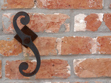 Close-up of a Red Brick Wall with a Wrought Iron Decoration Photographic Print