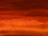 A Deep Red Sunset with Glowing Clouds and Dark Sky Photographic Print