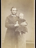 Man in a Frock Coat and Light Coloured Necktie Holds a Very Small Child on a Plinth Photographic Print