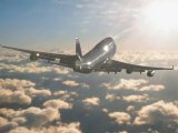 Jumbo Jet Above Clouds Into Sunlight Photographic Print by Peter Walton