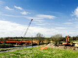 Crane Lifitng Steel Piling Beside River Avon During Construction of the Barford Bypass, England Lámina fotográfica por Martin Page Crane Lifitng Steel Piling Beside River Avon During Construction of the Barford Bypass, England Lámina fotográfica por Martin Page