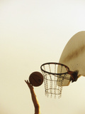 Person's Hand Holding a Basketball Near the Hoop Photographic Print