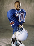 Boy in an Oversized Football Uniform Holding a Helmet Photographic Print