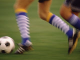 Low Section View of a Soccer Player Running with a Soccer Ball Photographic Print