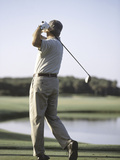 Rear View of a Senior Man Swinging a Golf Club Photographic Print