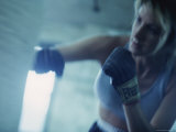 Female Boxer Punching a Punching Bag Photographic Print