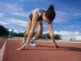Close-up of a Female Athlete in The Starting Position on a Running Track Lámina fotográfica