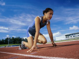 Close-up of a Female Athlete in The Starting Position on a Running Track Lámina fotográfica