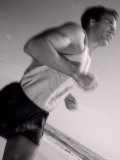 Side Profile of a Young Man Jogging on the Beach Photographic Print