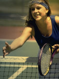 Young Woman Reaching Out over a Net at the Tennis Court Photographic Print