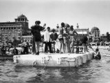 Several Young Men and Women on a Platform in the Water, Some of Them Dancing, on the Lido of Venice Fotografie-Druck