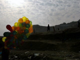 A Boy Walks as Selling Balloons in a Neighborhood in Kabul, Afghanistan, Thursday, August 24, 2006 Photographie par Rodrigo Abd