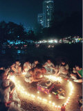 At the Center of Candle-Lit Circle, a Man Slices a Cake Photographic Print