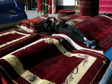 A Masked Boy Rests at a Carpet Shop in Kabul, Afghanistan, Friday, September 22, 2006 Photographie par Rodrigo Abd