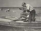 A Hungarian Fisherman, Standing up on a Boat, Weighs Some Fish with a Steelyard Photographic Print