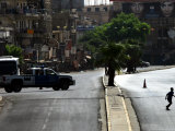 An Iraqi Boy Runs Across a Deserted Street Photographic Print