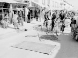 Rugs Get Instant Antiquing Treatment from Bicycle Riders Which Helps Make the Price Go Up Photographic Print
