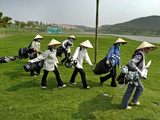 Women Wearing the Traditional Vietnamese Conical Hats Haul Golf Clubs Photographic Print