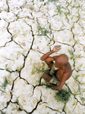 An Indian Farmer Sits in His Dried up Field in Hanumanganj, India Photographic Print