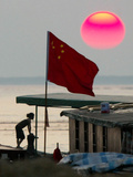 A Girl Rests on a Boat Below the Chinese National Flag Photographic Print