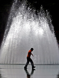 A Boy Crosses Over a Fountain Photographic Print