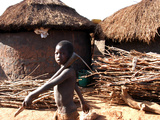 A Young Boy Carries a Hoe Photographic Print